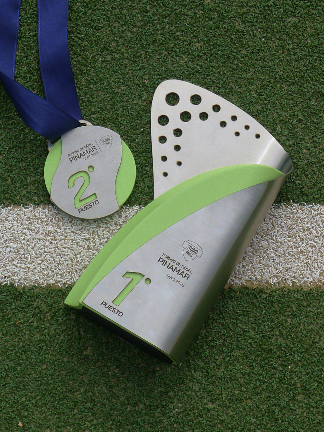 El trofeo y la medalla sobre el césped sintético de la cancha